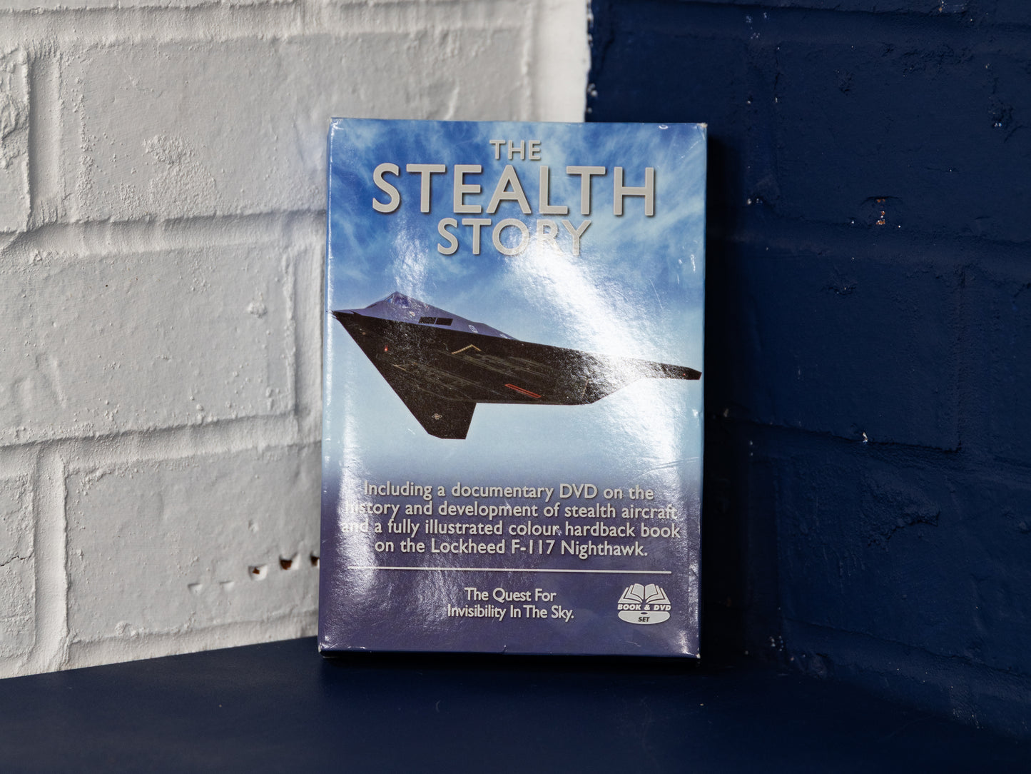 Front-on view of The Stealth Story box set against blue wall.
