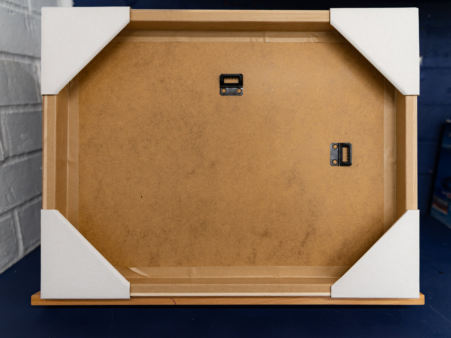 Rear of frame showing ash surround and two wall-mount hangers.