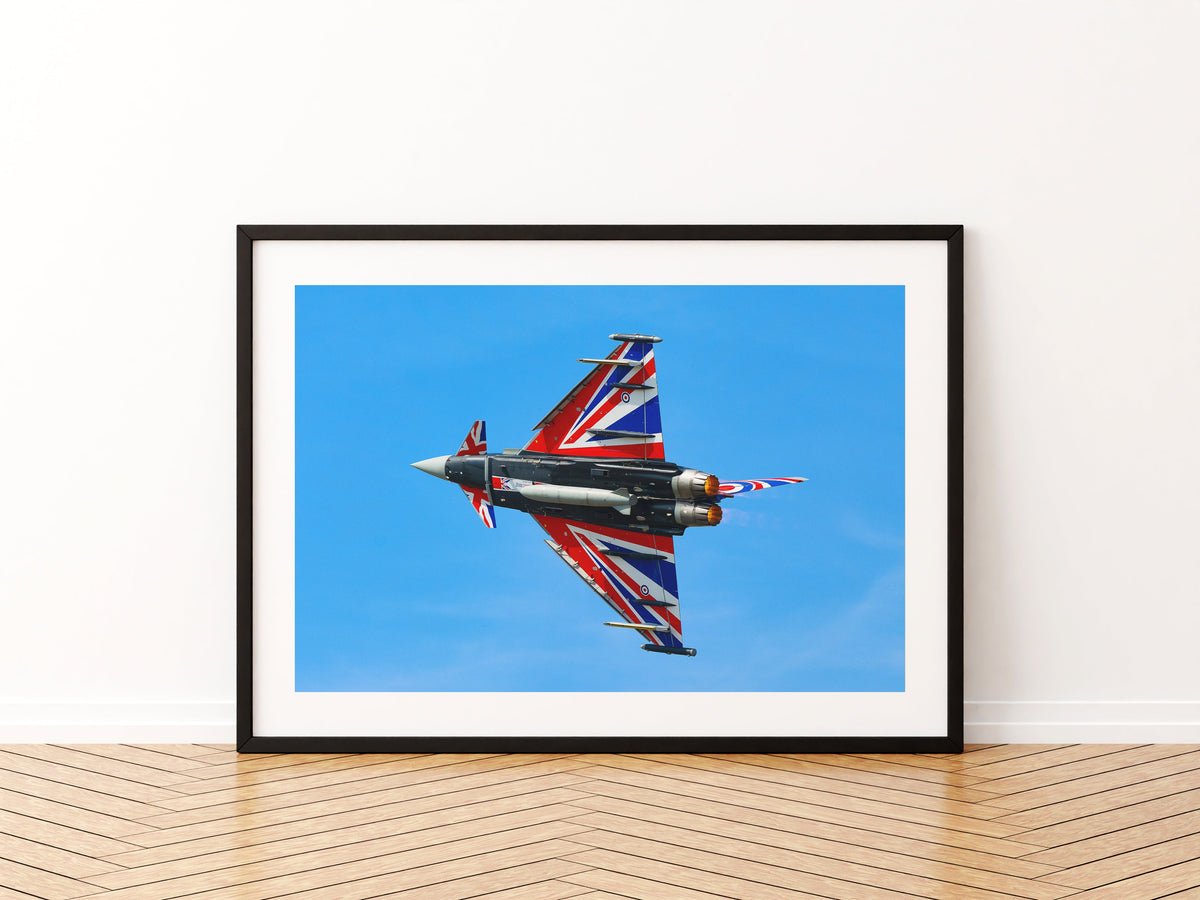 RAF Typhoon display jet Blackjack showing the Union flag on its underside against a blue sky, aviation photo wall art print in a black frame