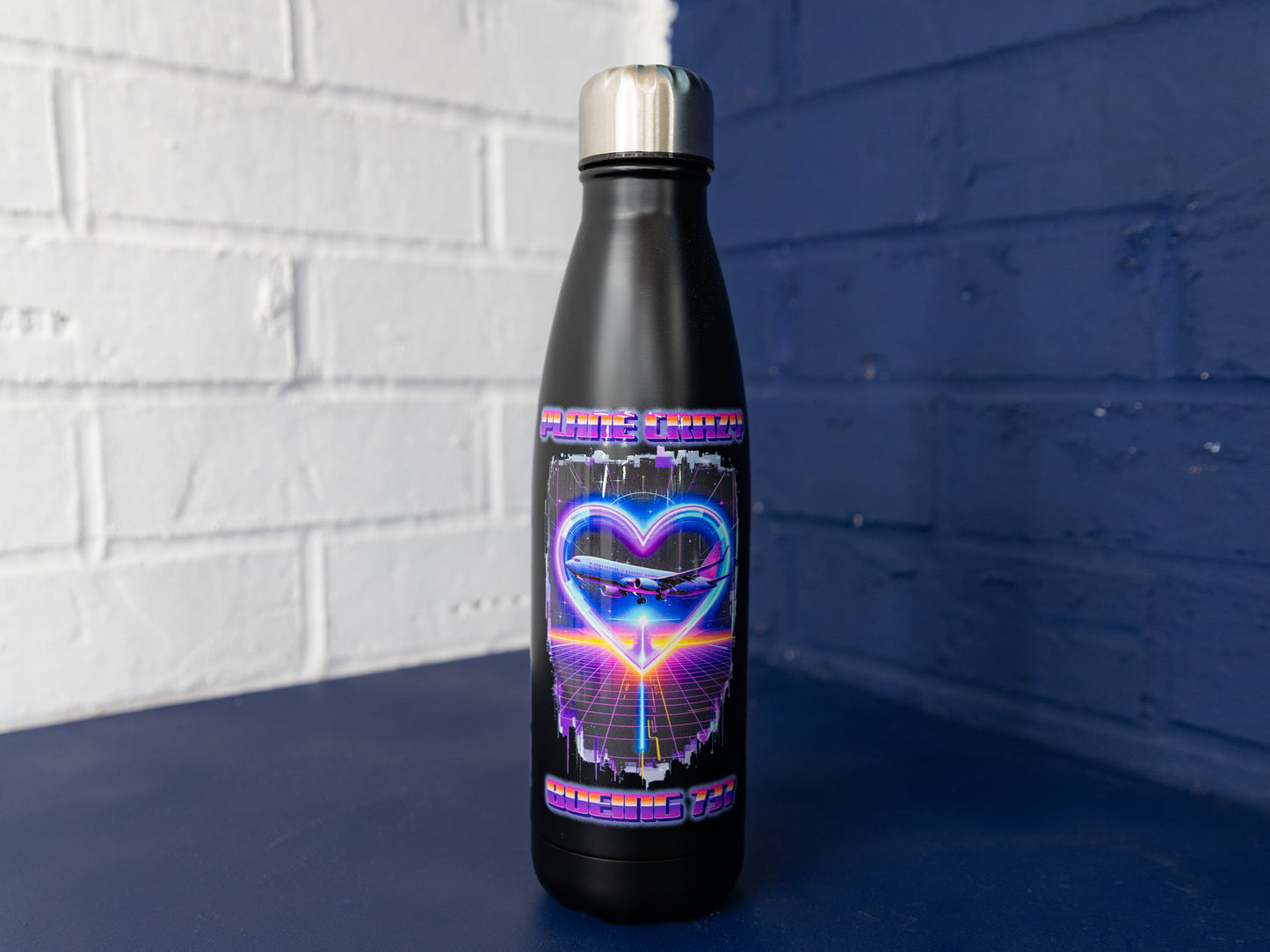 Front view of matte black Plane Crazy Boeing 737 prototype bottle with stainless cap.