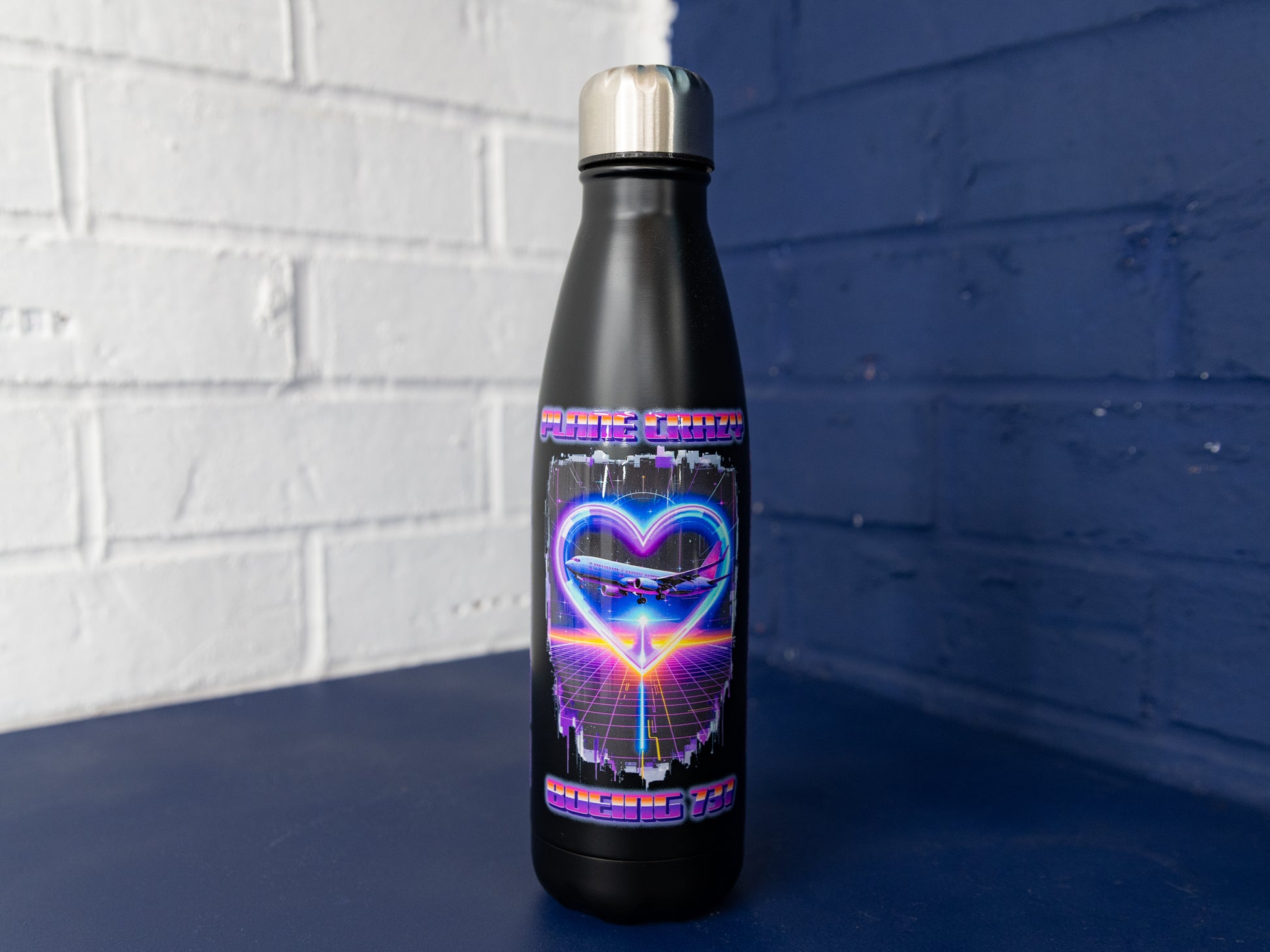 Front view of matte black Plane Crazy Boeing 737 prototype bottle with stainless cap.