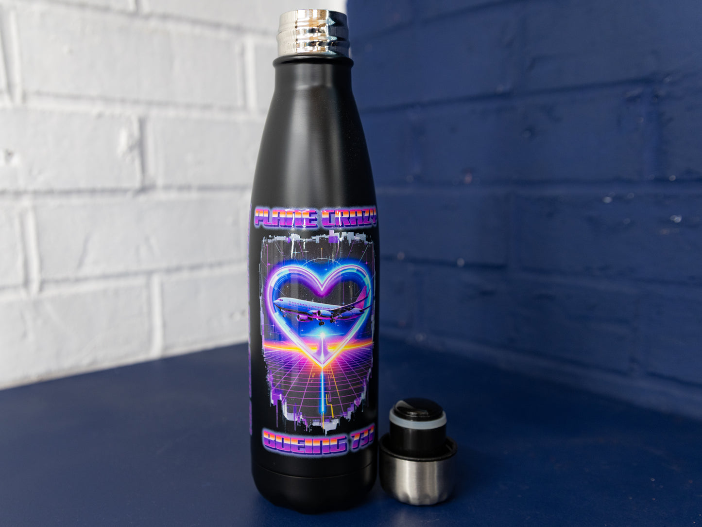Bottle with cap removed showing printed 737 neon heart artwork.