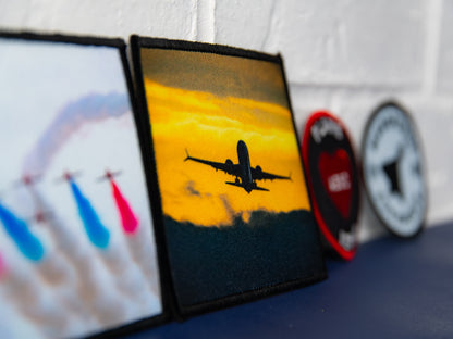 Angled close-up of sunset airliner photo art square patch.