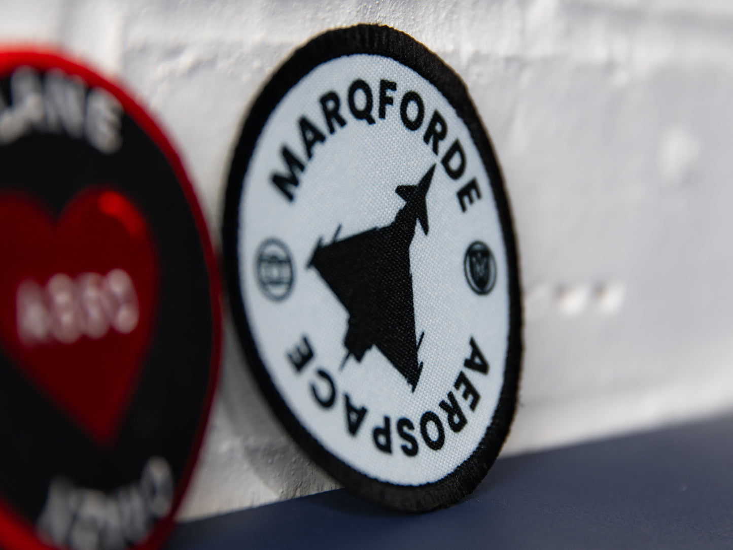 Close-up of Marqforde Aerospace round crest patch with jet silhouette.