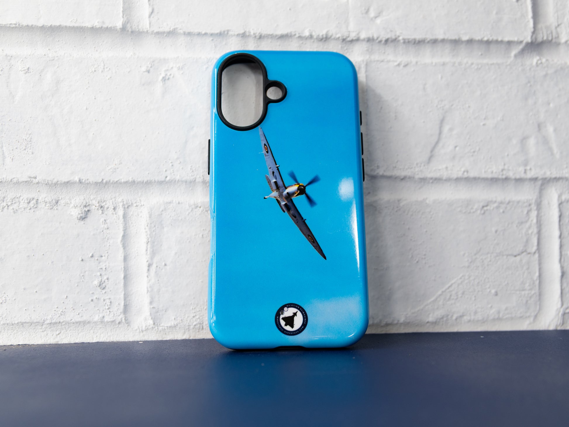 Straight-on product shot of the Spitfire artwork case on a blue surface.