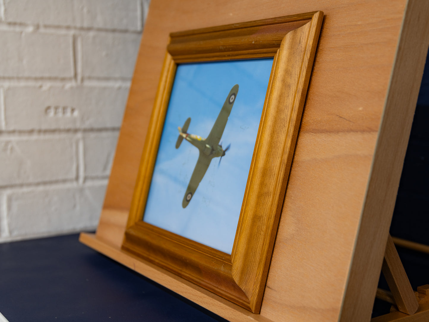 Wider angled shot of framed Hurricane against wooden easel.