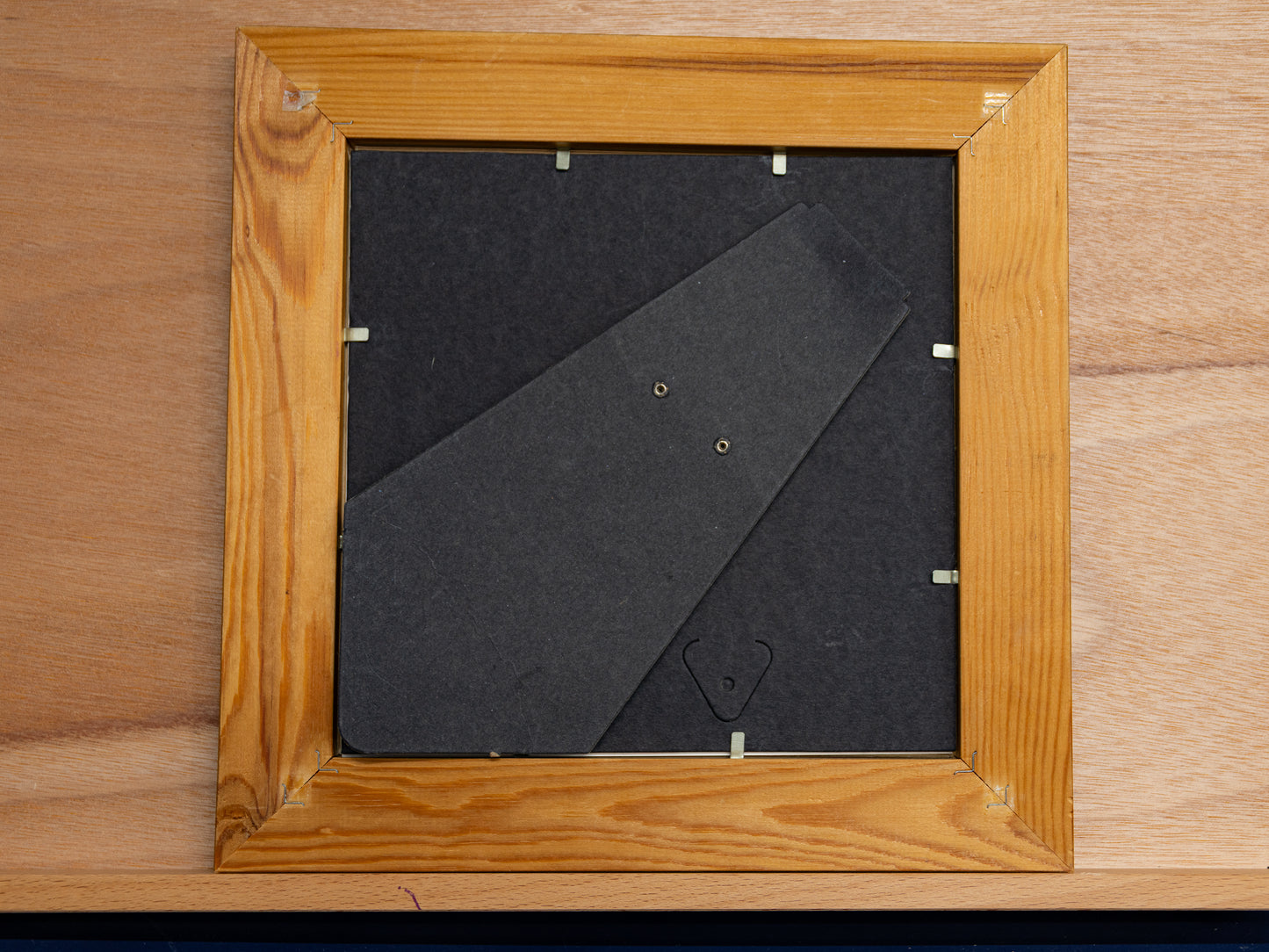 Back of wooden frame with standing arm and clips.