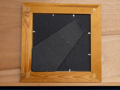Back of wooden frame with standing arm and clips.