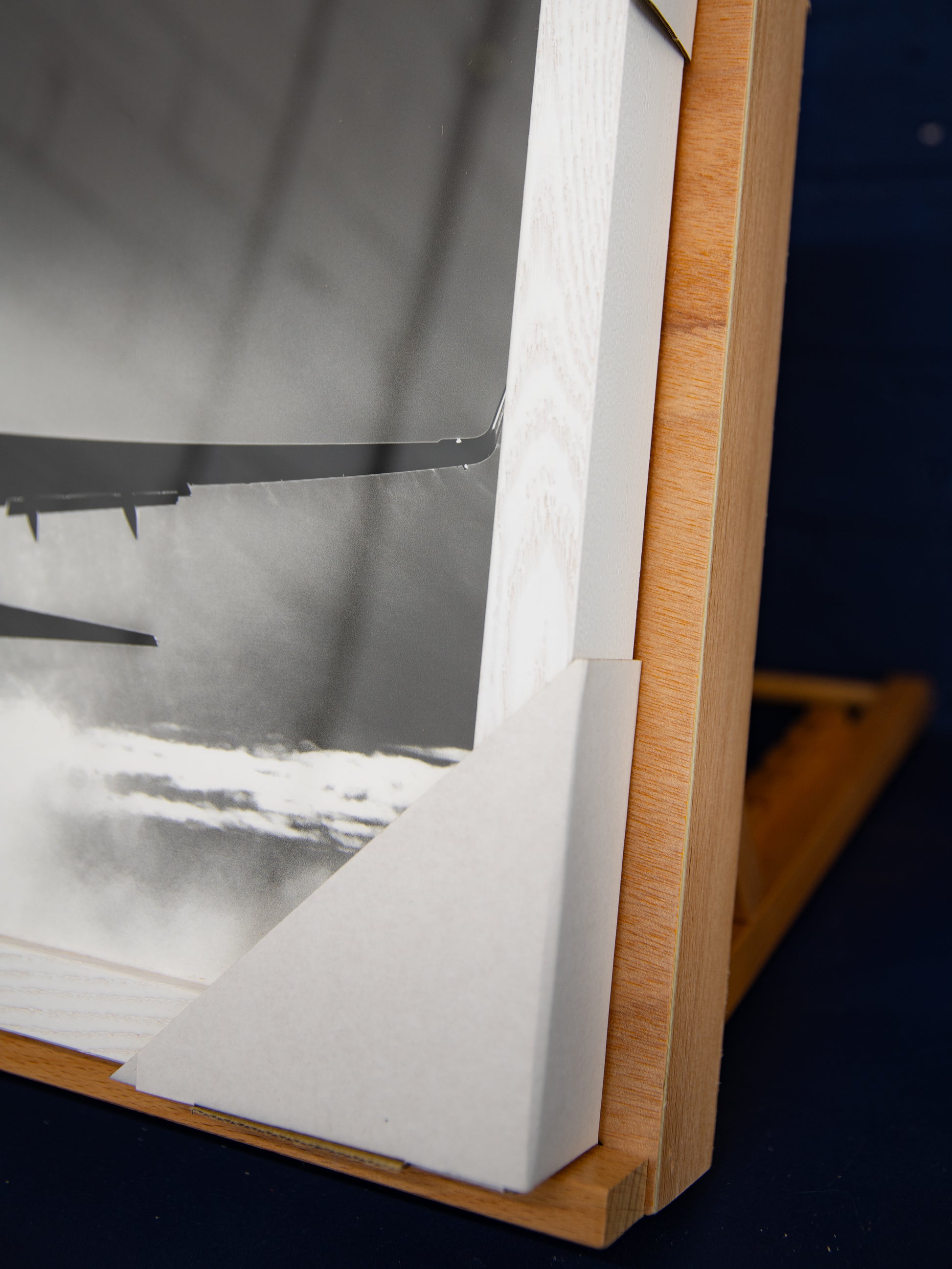 Close-up of lower frame corner and print edge inside the shadow box.