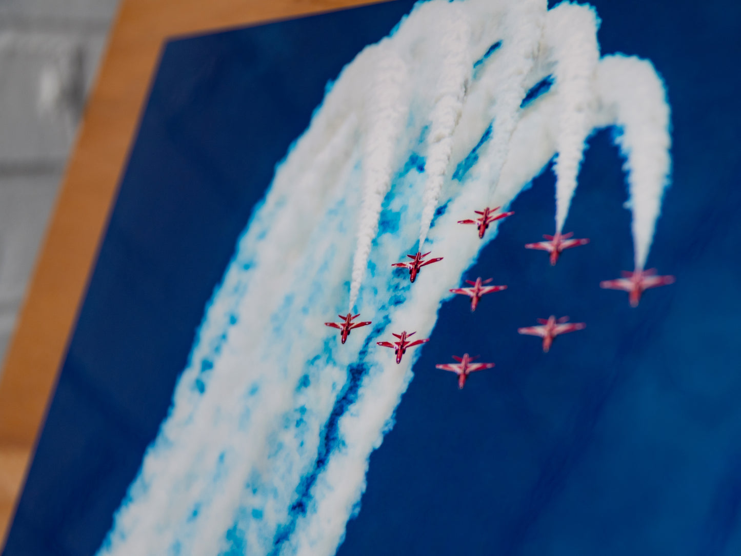 Close-up of jets with sweeping smoke trails on glossy metallic paper.