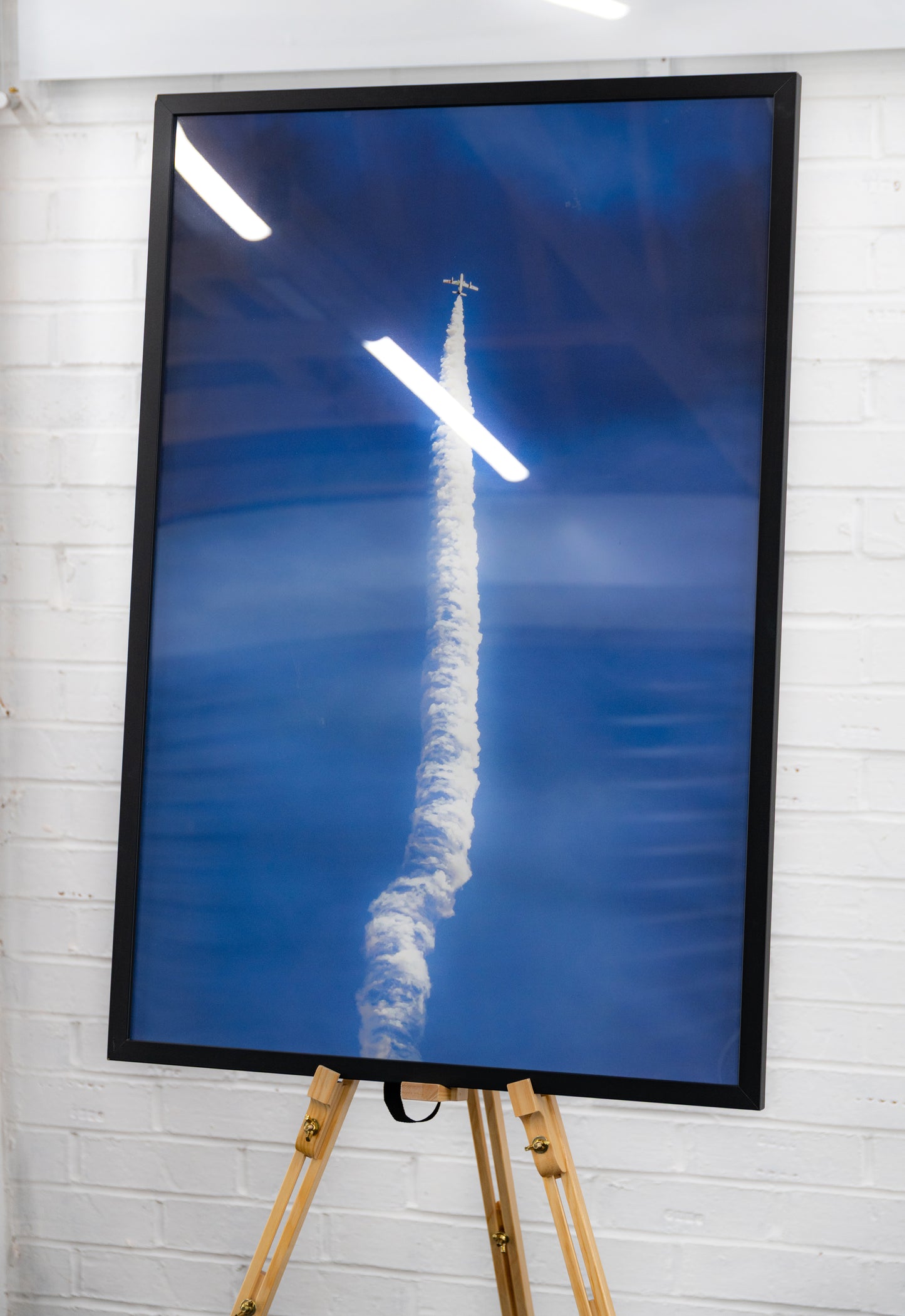 Three-quarter view of the framed Frecce Tricolori Solo Ascent print on an easel.