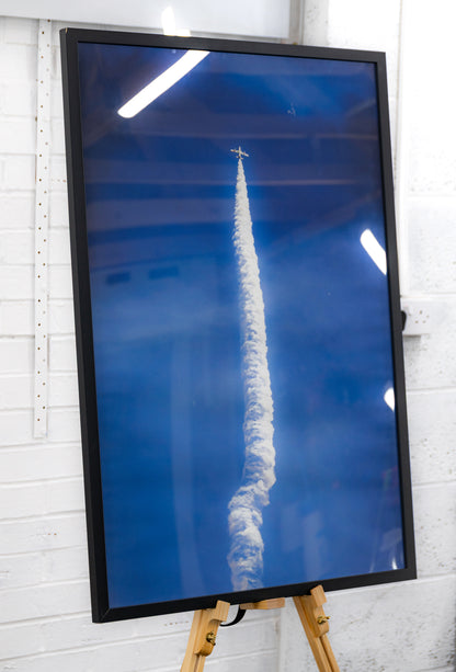 Angled full view of the tall framed print against a studio wall.