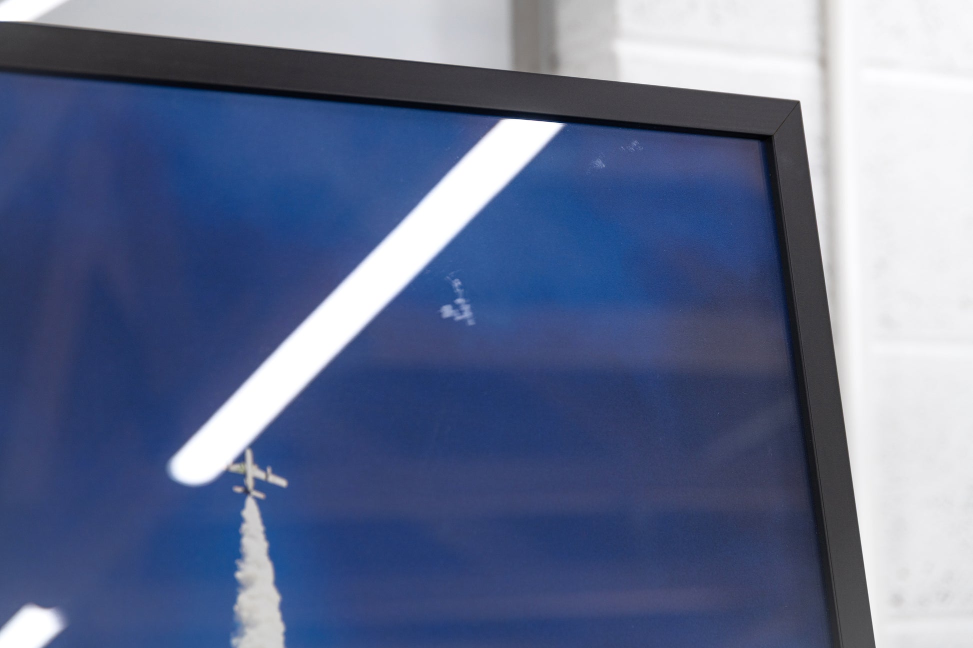 Glazing close-up highlighting faint marks near the upper edge of the print