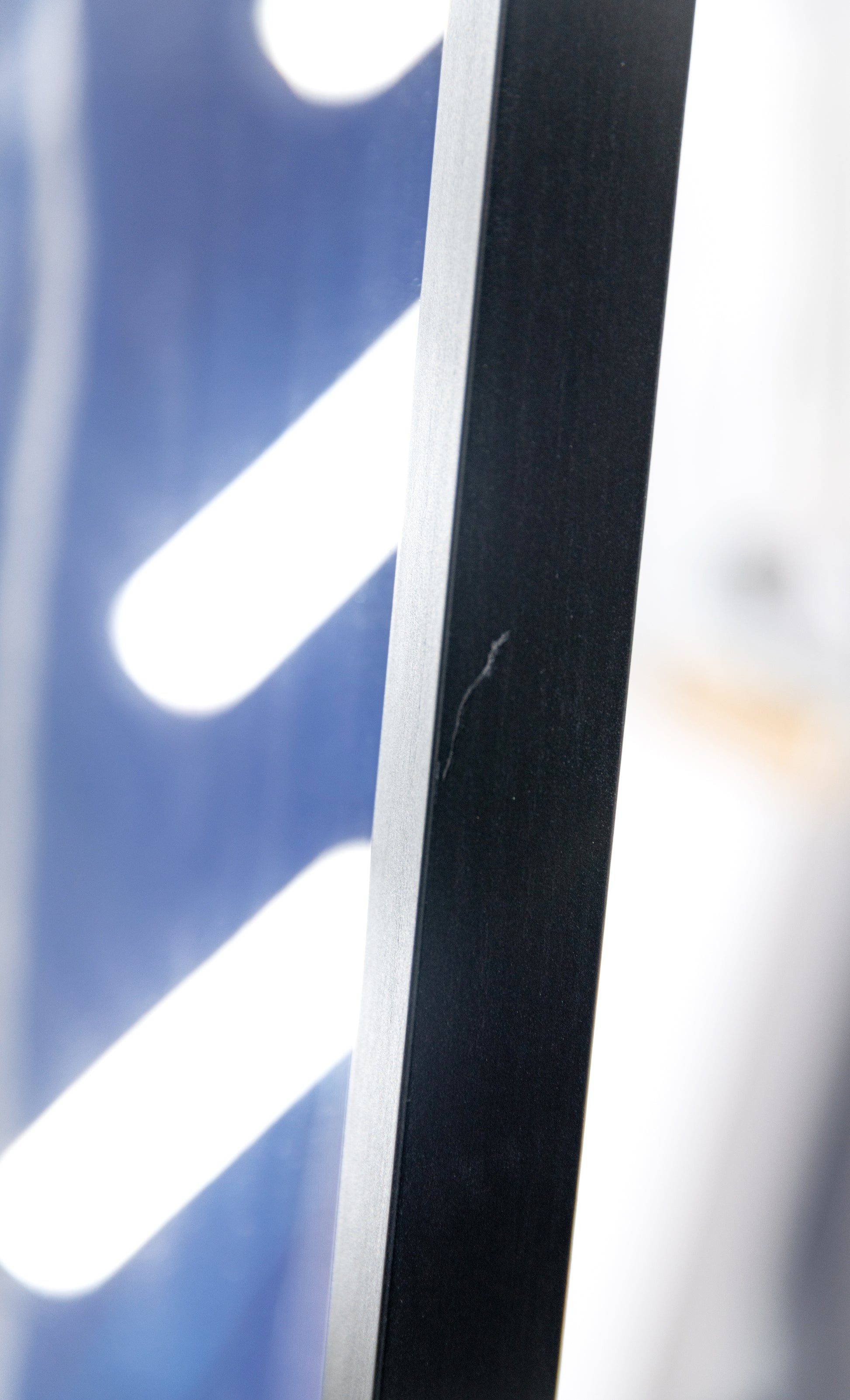 Detail of a light surface scratch on the black side rail of the frame