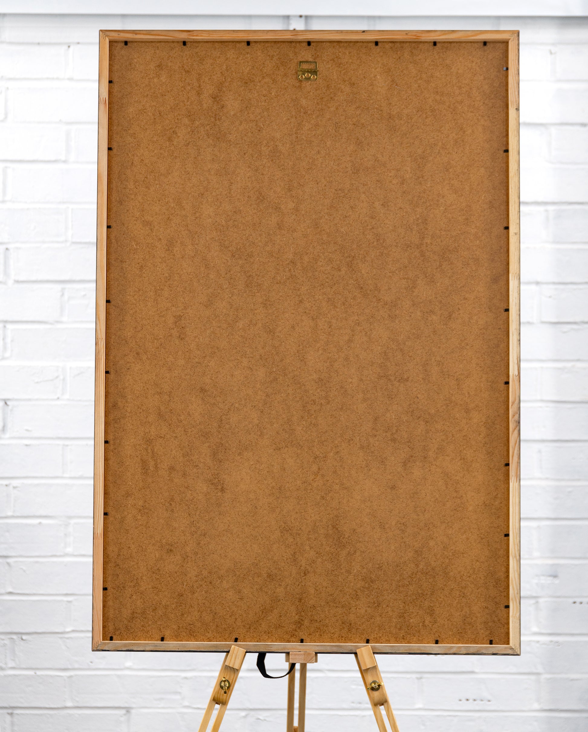Rear view of the large framed poster showing brown MDF backing and a central sawtooth hanging bracket.