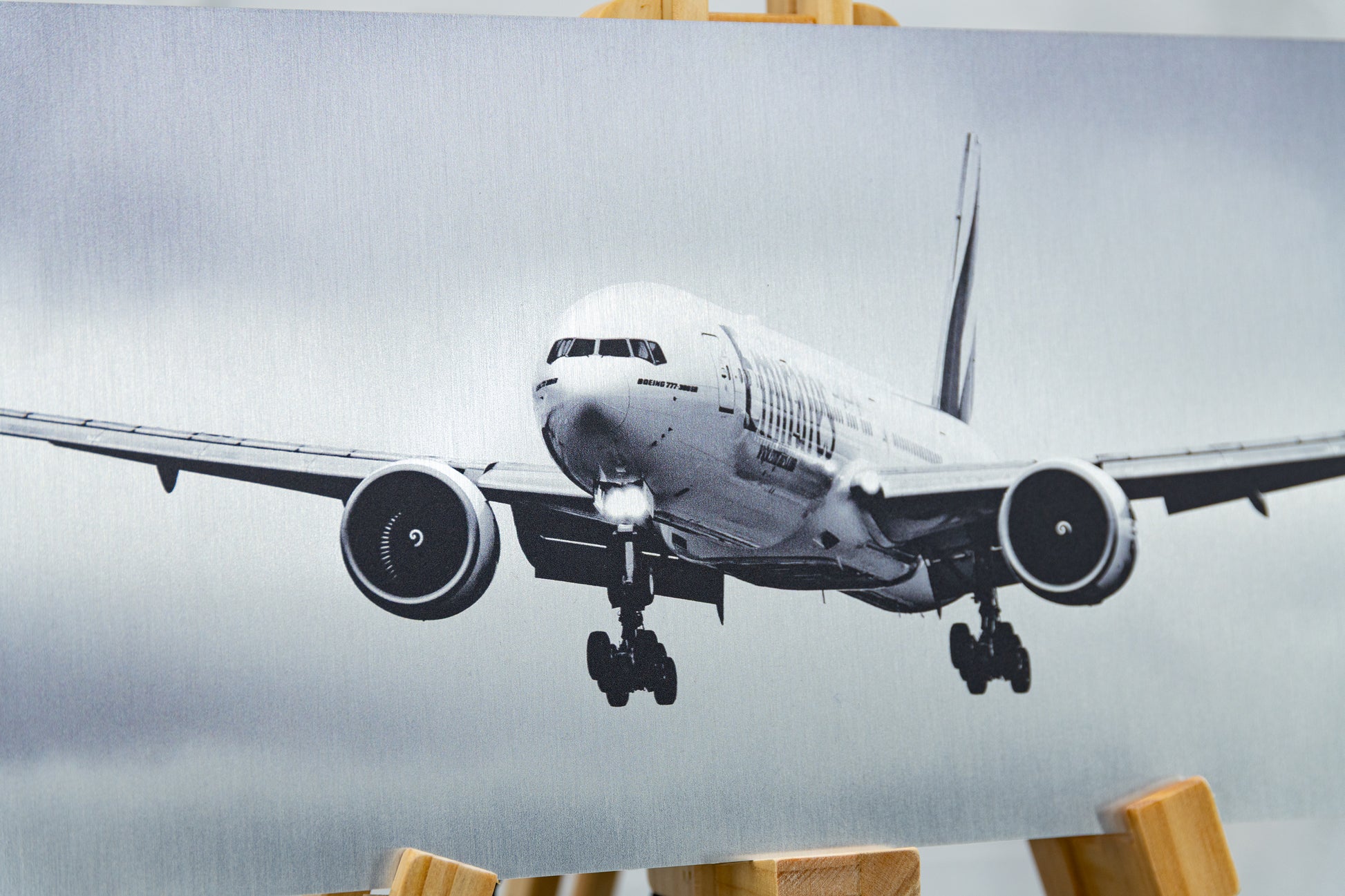Close-up of Emirates Boeing 777-300ER nose and engines printed on brushed aluminium, showing metallic grain