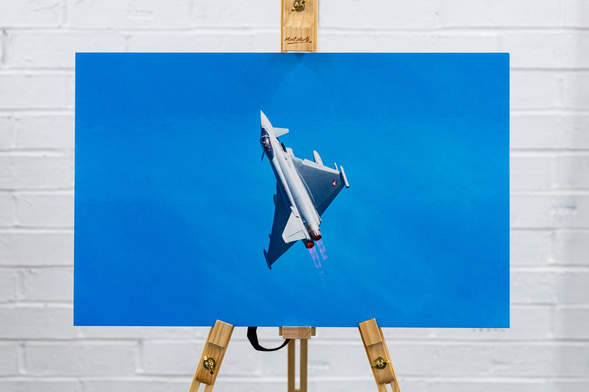 Front view of glossy foamboard Typhoon QRA climbout print centered on easel against studio wall.