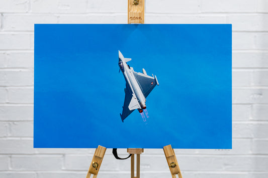Front view of glossy foamboard Typhoon QRA climbout print centered on easel against studio wall.