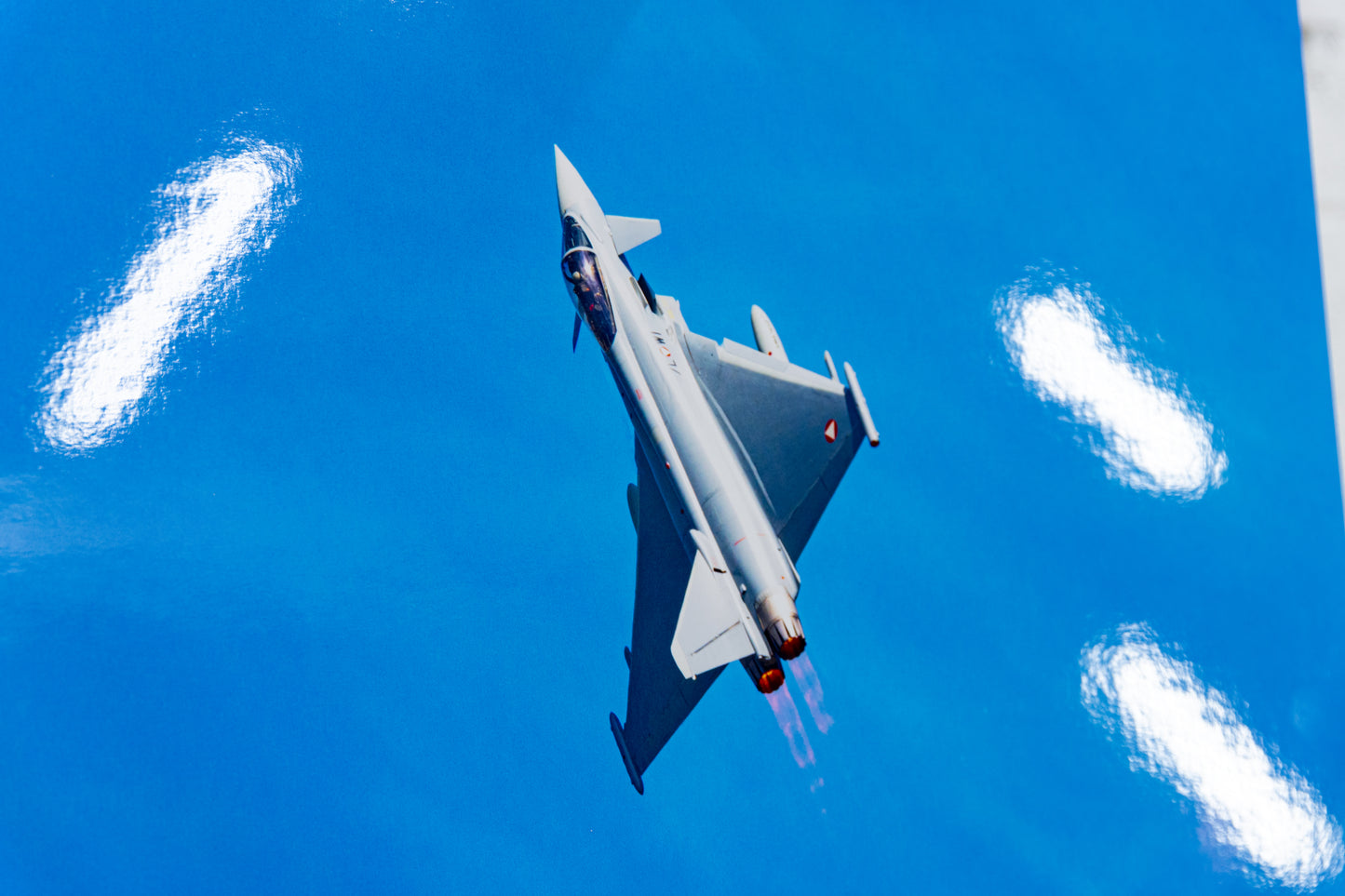 Detail of Eurofighter Typhoon with reheat plumes on glossy photo surface, gloss reflections visible.