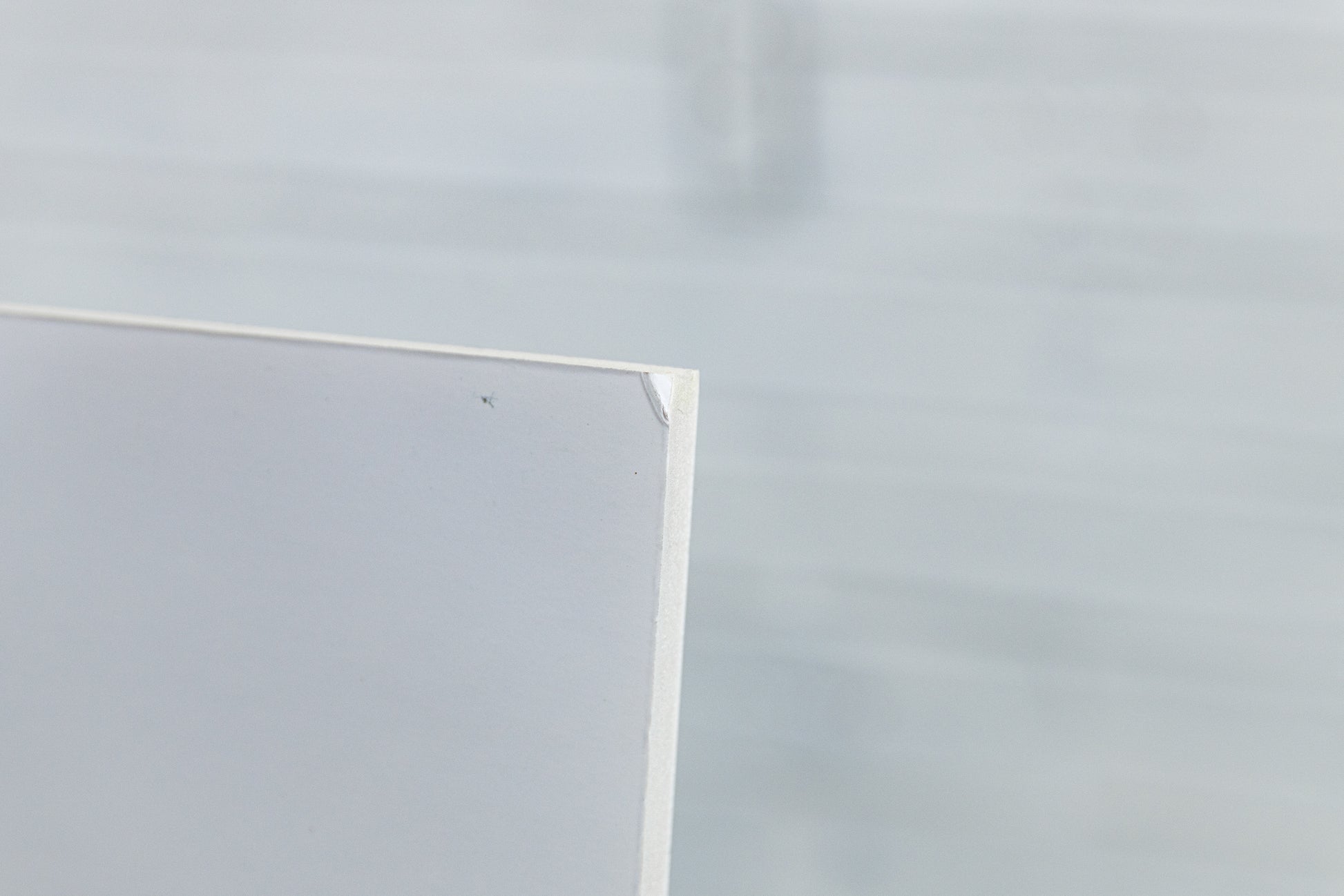 Close-up of foamboard edge and laminate wrap, minor handling wear visible.