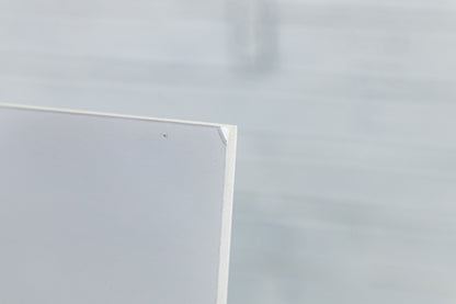 Close-up of foamboard edge and laminate wrap, minor handling wear visible.