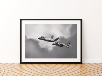 RAF F-35B Lightning II and Spanish Navy Harrier II flying together, black and white, aviation photo wall art print in a black frame